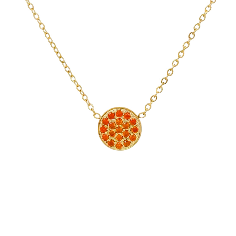 Gold necklace with a round pendant featuring orange red  stones on a white background