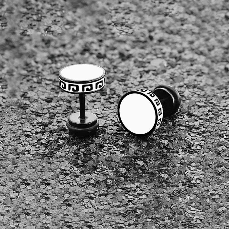 Pair of black and white earrings on a textured surface