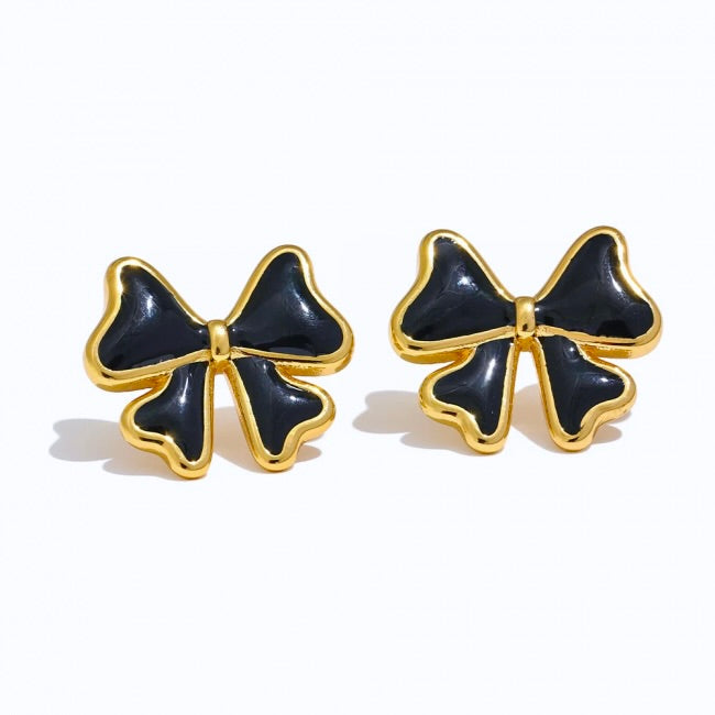 Black bow-shaped earrings with gold accents on a white background