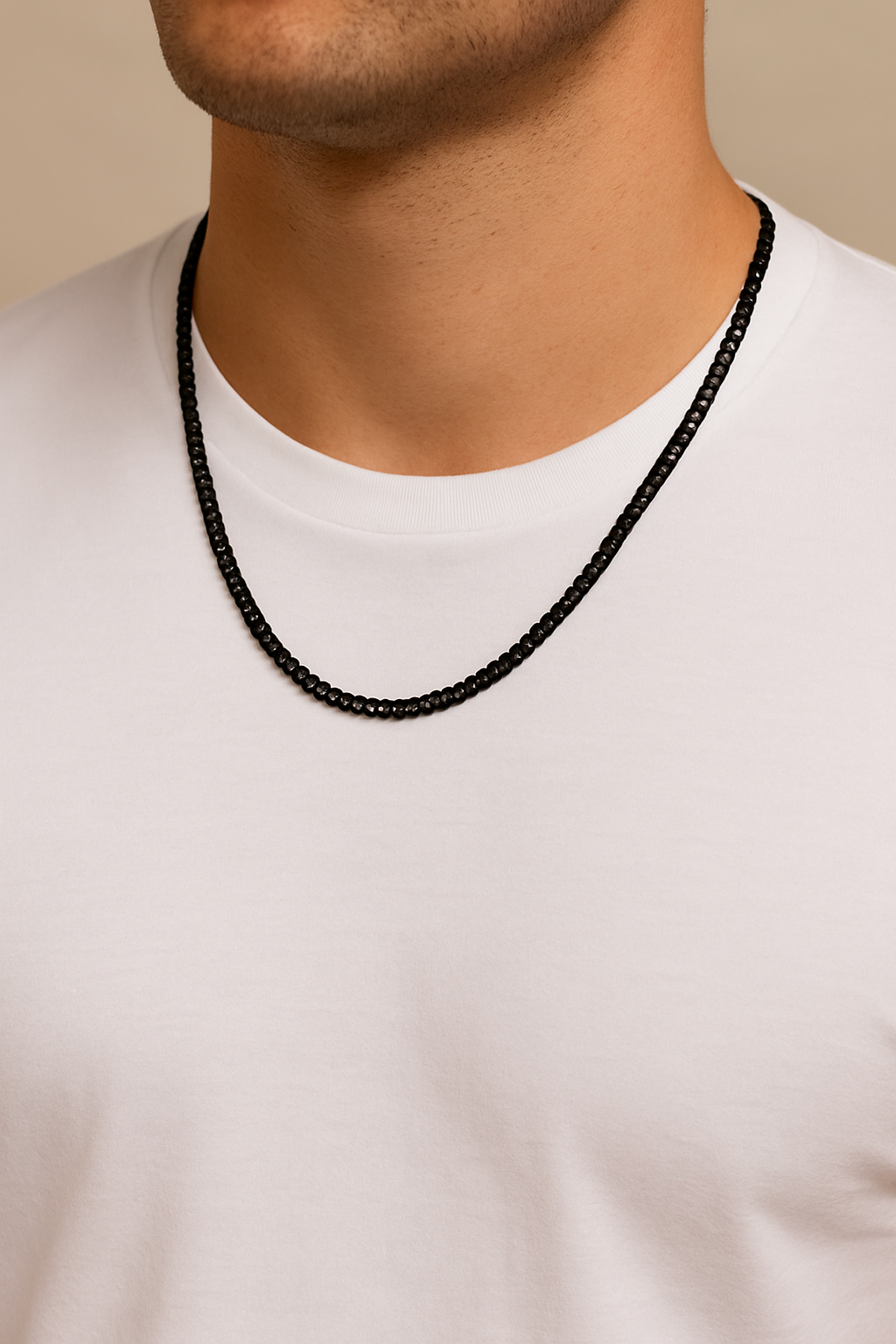 Person wearing a black beaded necklace against a neutral background