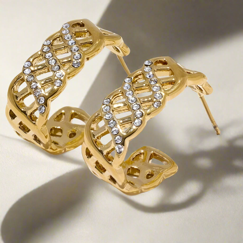 Gold hoop earrings with diamond accents on a white shadow-background