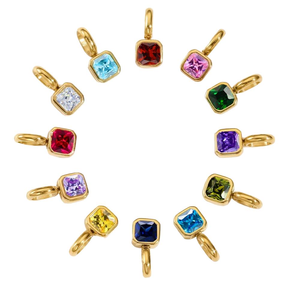 Gold pendants with colorful gemstones on a white background