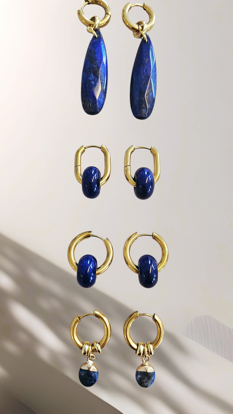 Set of gold and blue earrings on a light background