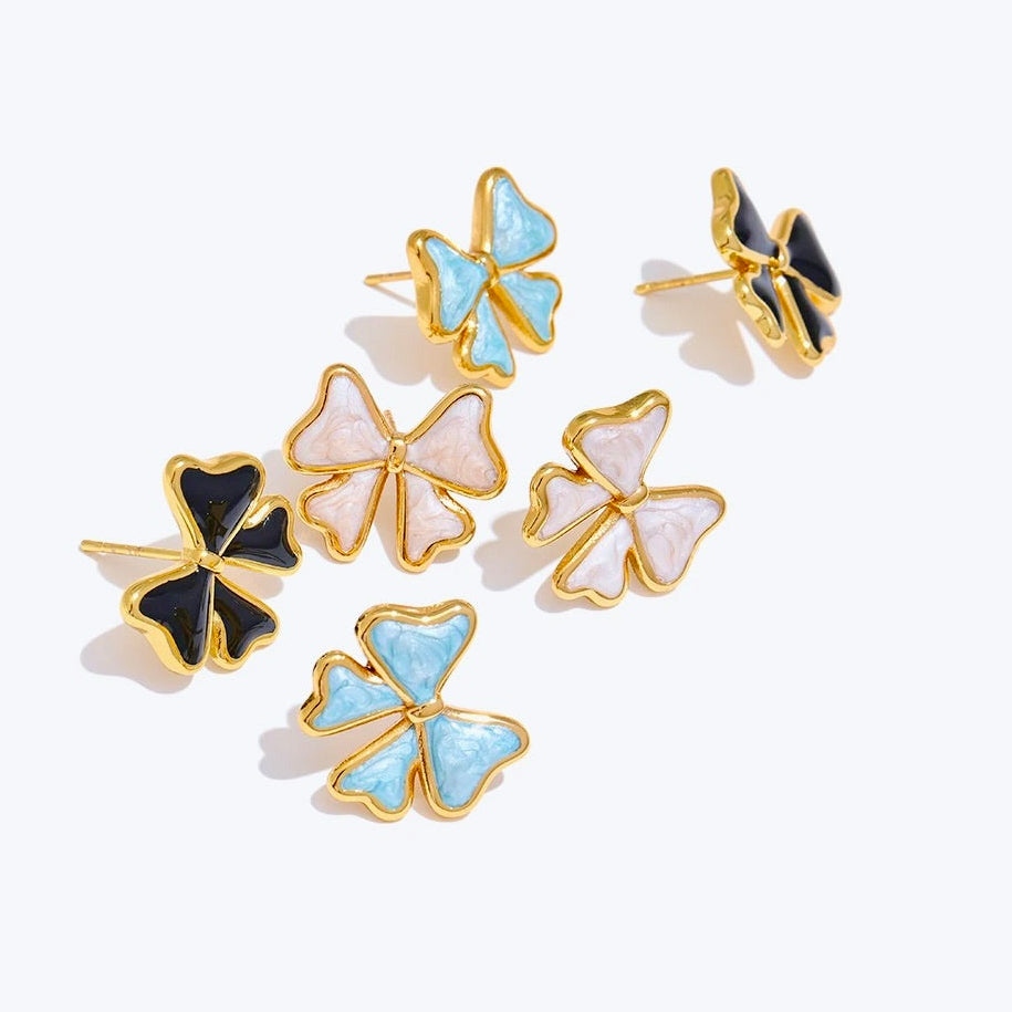 Bow-shaped earrings with gold and color accents on a white background