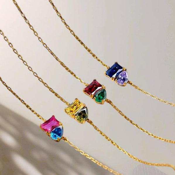 Gold bracelets with colorful gemstones on a neutral background