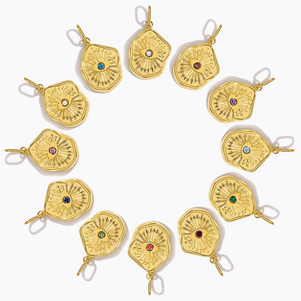 Gold pendants with embedded gemstones on a white background