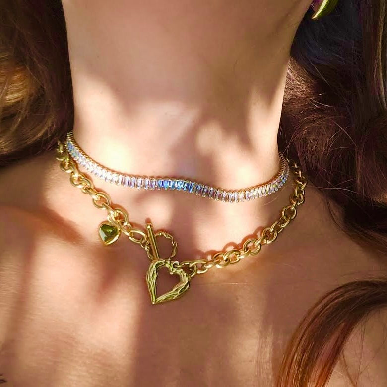 Woman wearing gold heart chain necklace with toggle clasp
