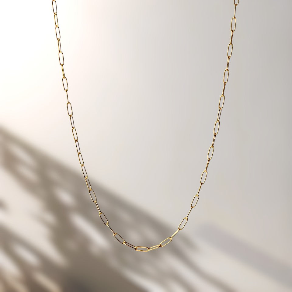 Gold chain necklace on a light background