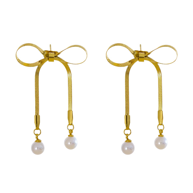 Pair of gold earrings with bow design and pearl drops on a white background