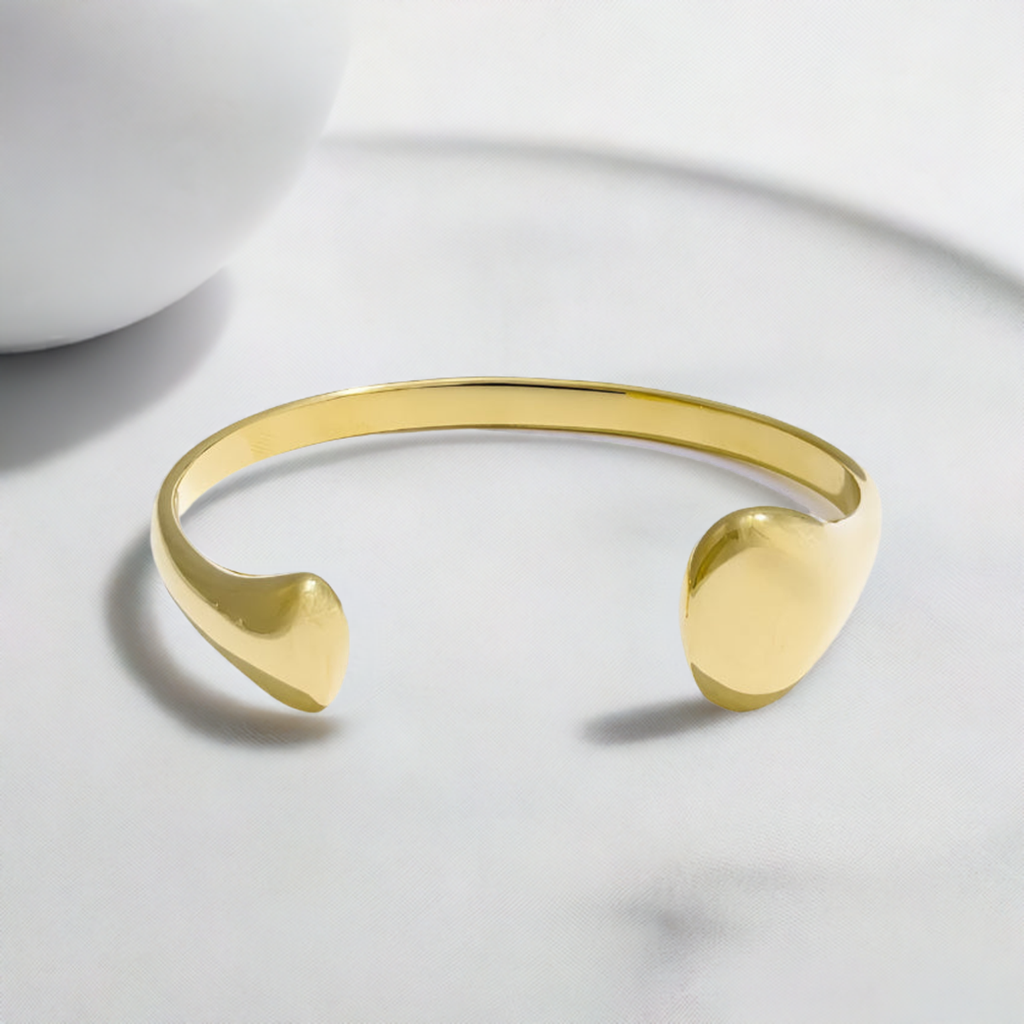 A gold plated open cuff modern design bracelet in stainless steel.