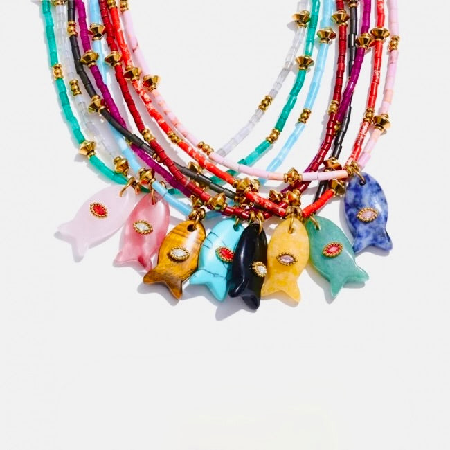 Colorful necklaces with fish charms on a white background