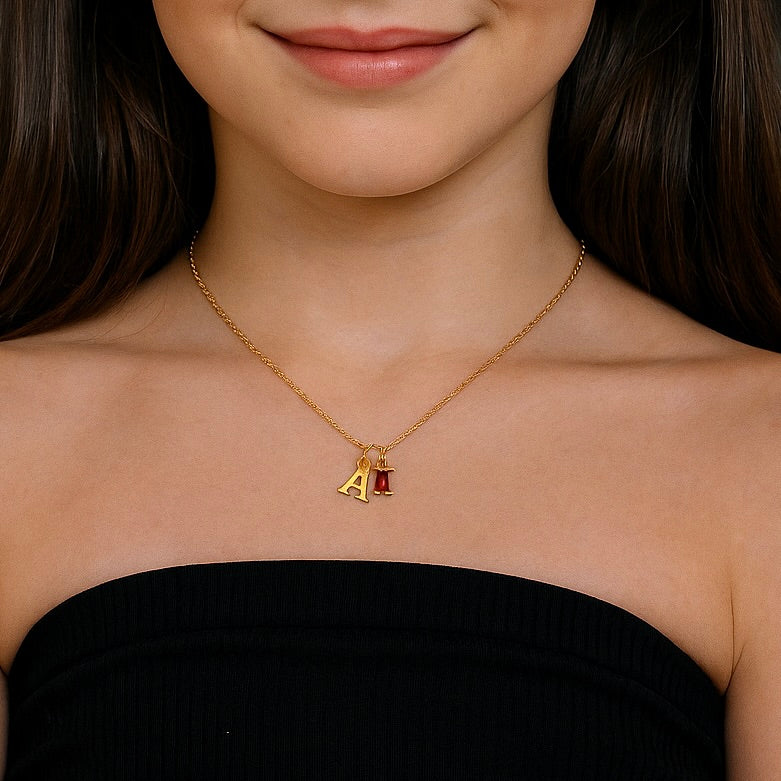 Woman wearing a gold necklace with a pendant featuring the letter 'A'.