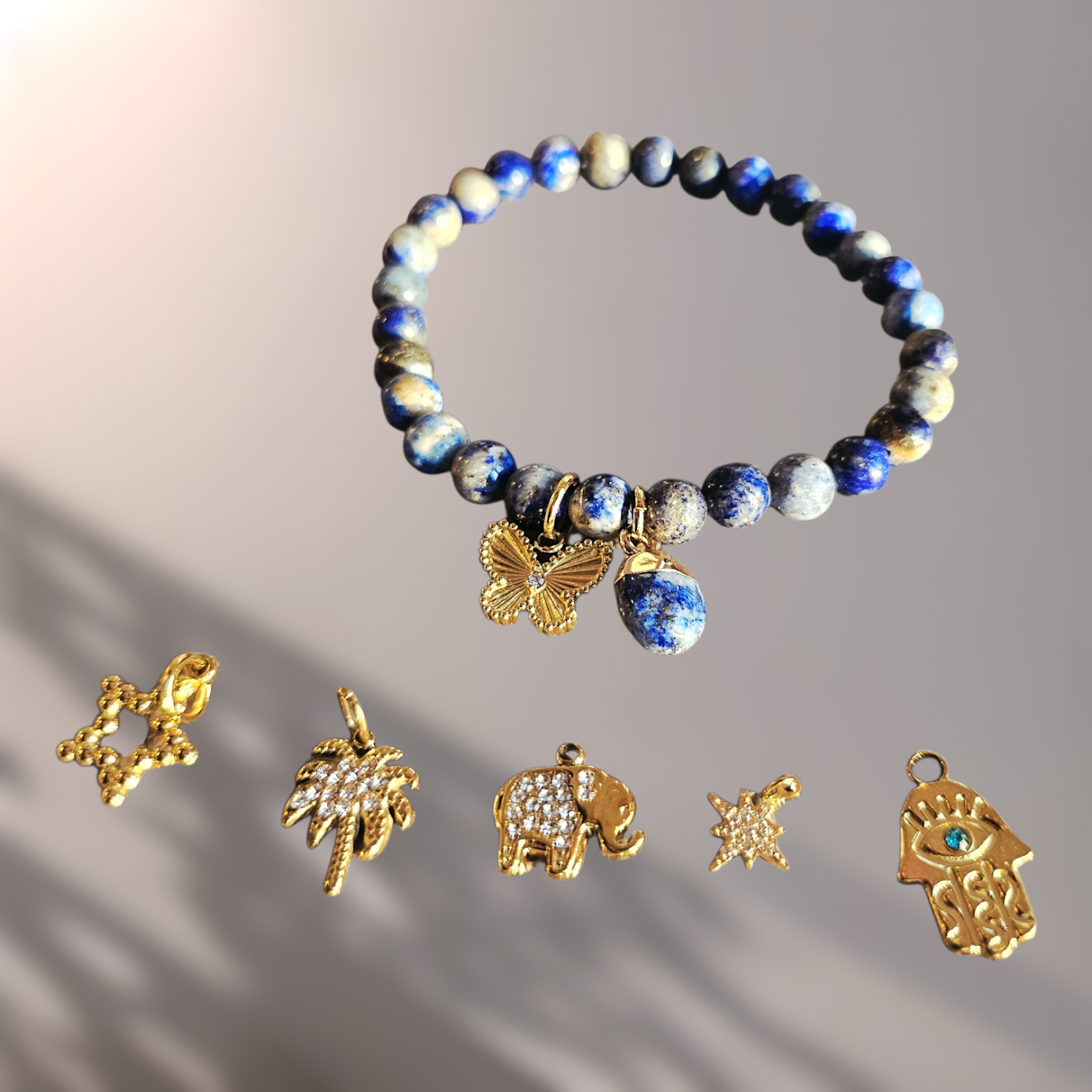 Bracelet with blue and gold beads and charms on a gradient background