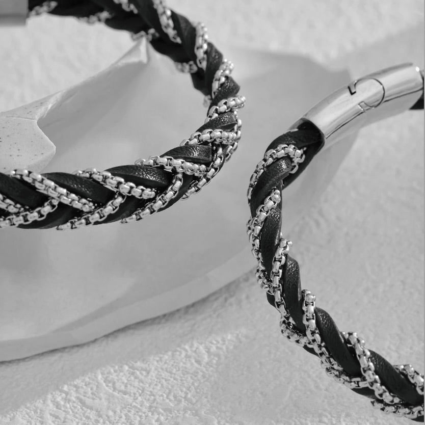 Close-up of a braided black and silver bracelet on a white background