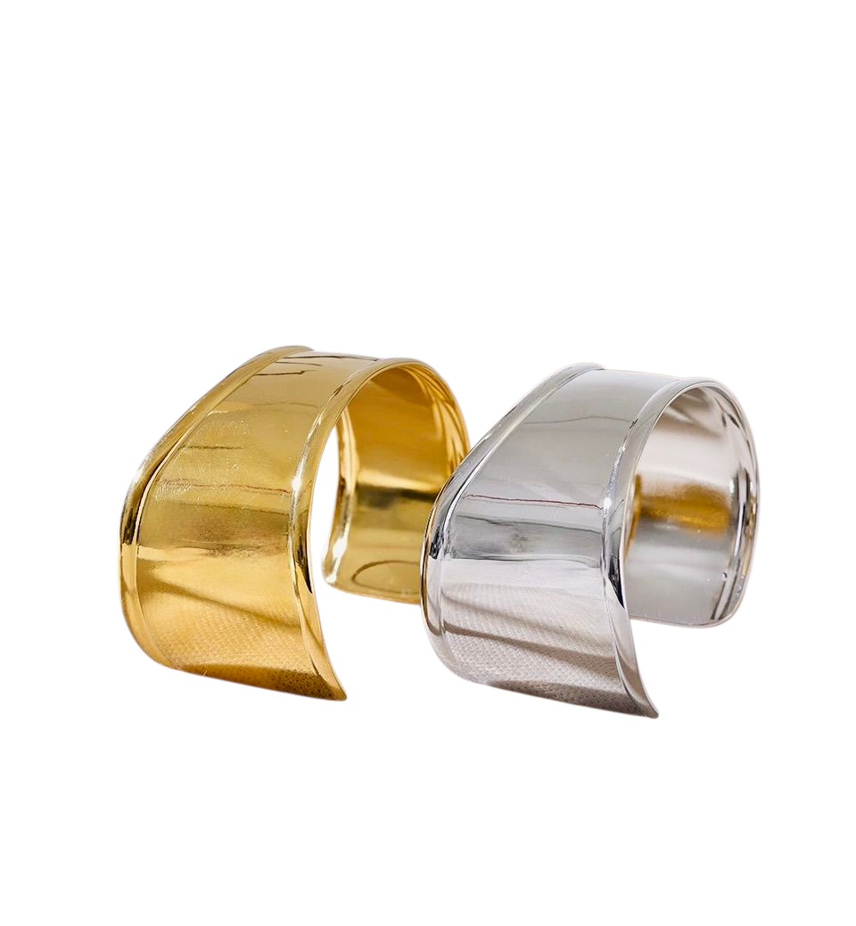 Gold and silver cuff bracelets on a white background