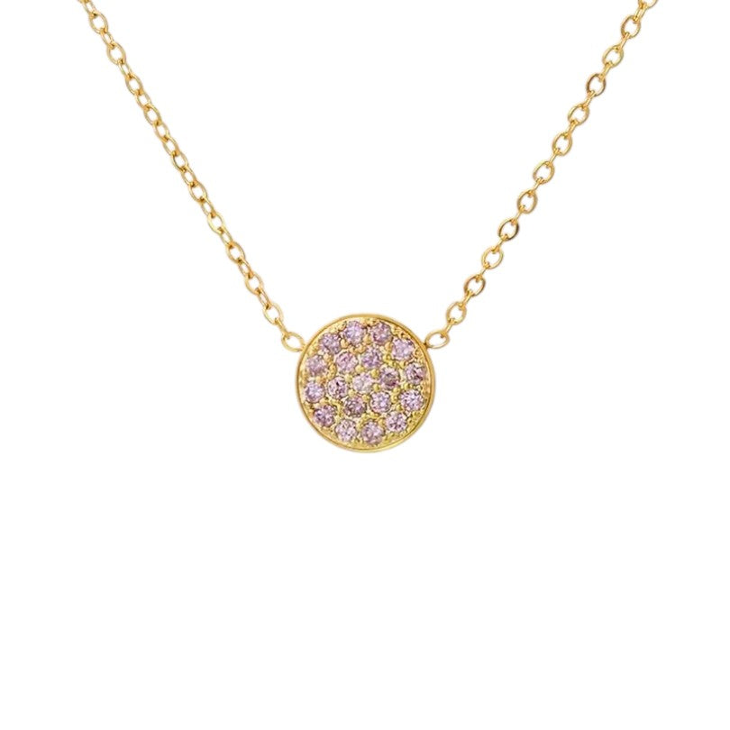 Gold necklace with a pink gemstone pendant on a white background