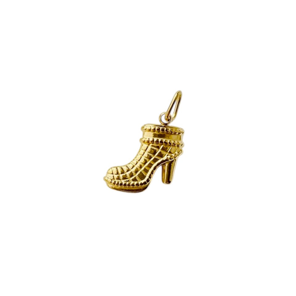 Gold high-heeled shoe charm on a white background