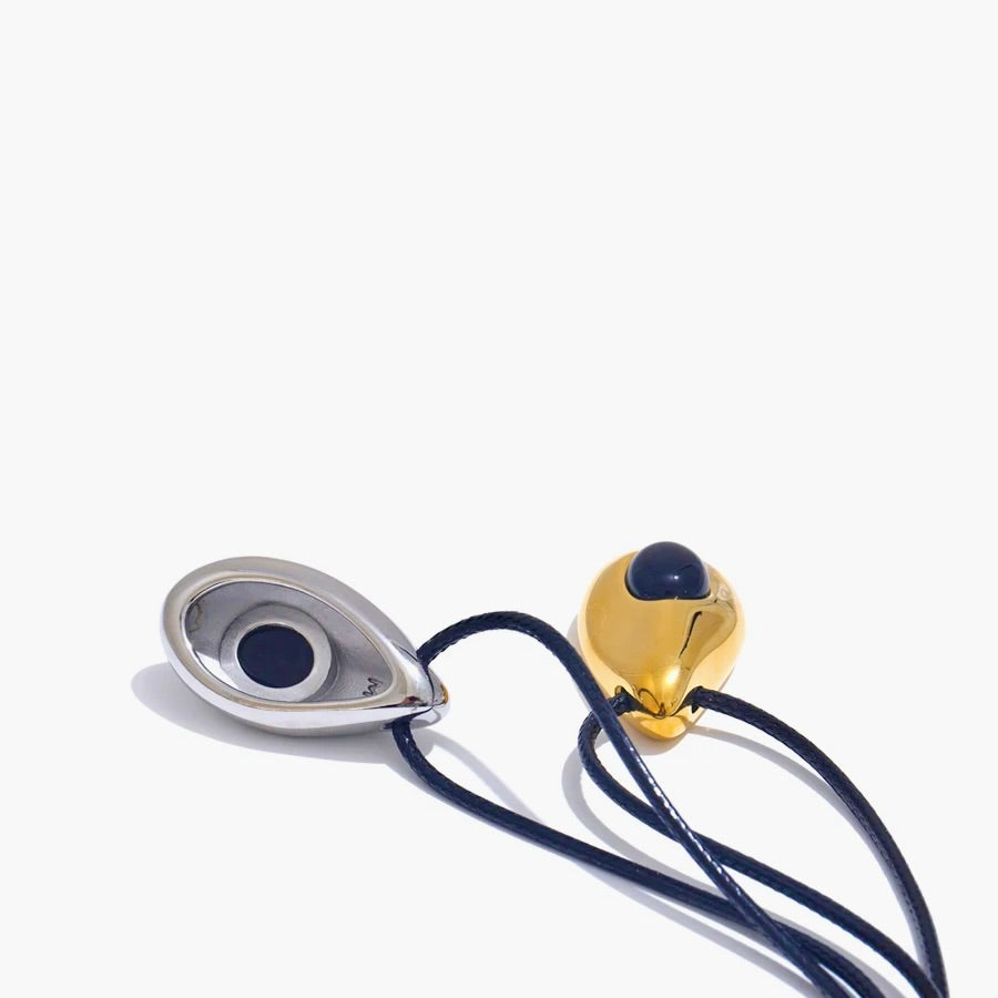 Jewelry set with a gold and silver pendant on a white background