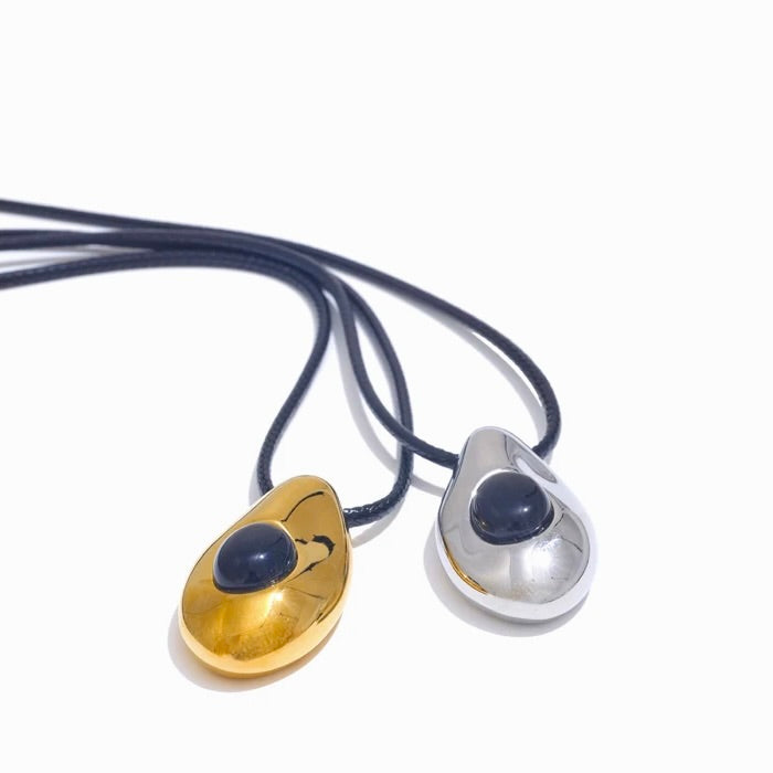 Two pendant necklaces, one gold and one silver, on a white background