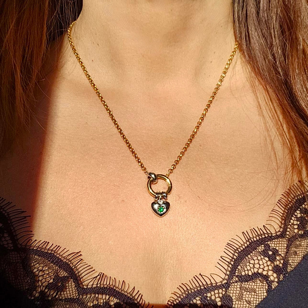 Gold necklace with a heart-shaped pendant worn by a woman