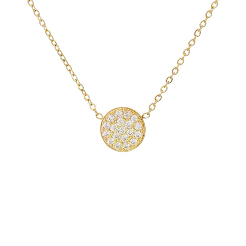 Gold necklace with a round, diamond-studded pendant on a white background