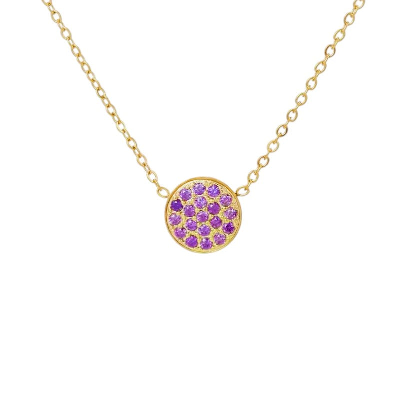 Gold necklace with a round pendant featuring purple gemstones on a white background