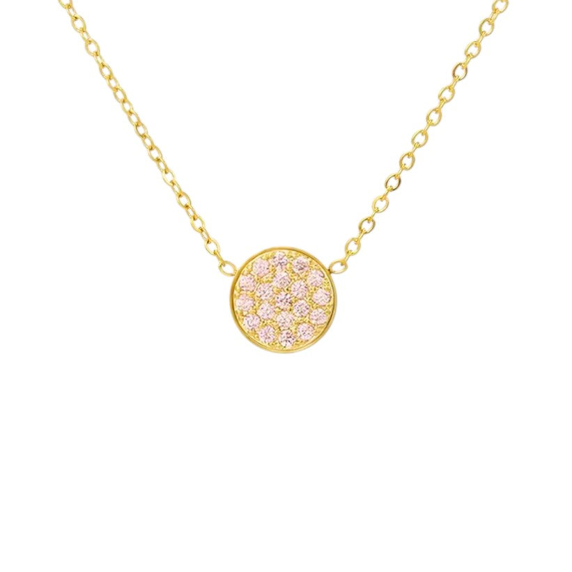 Gold necklace with a round pink gemstone pendant on a white background
